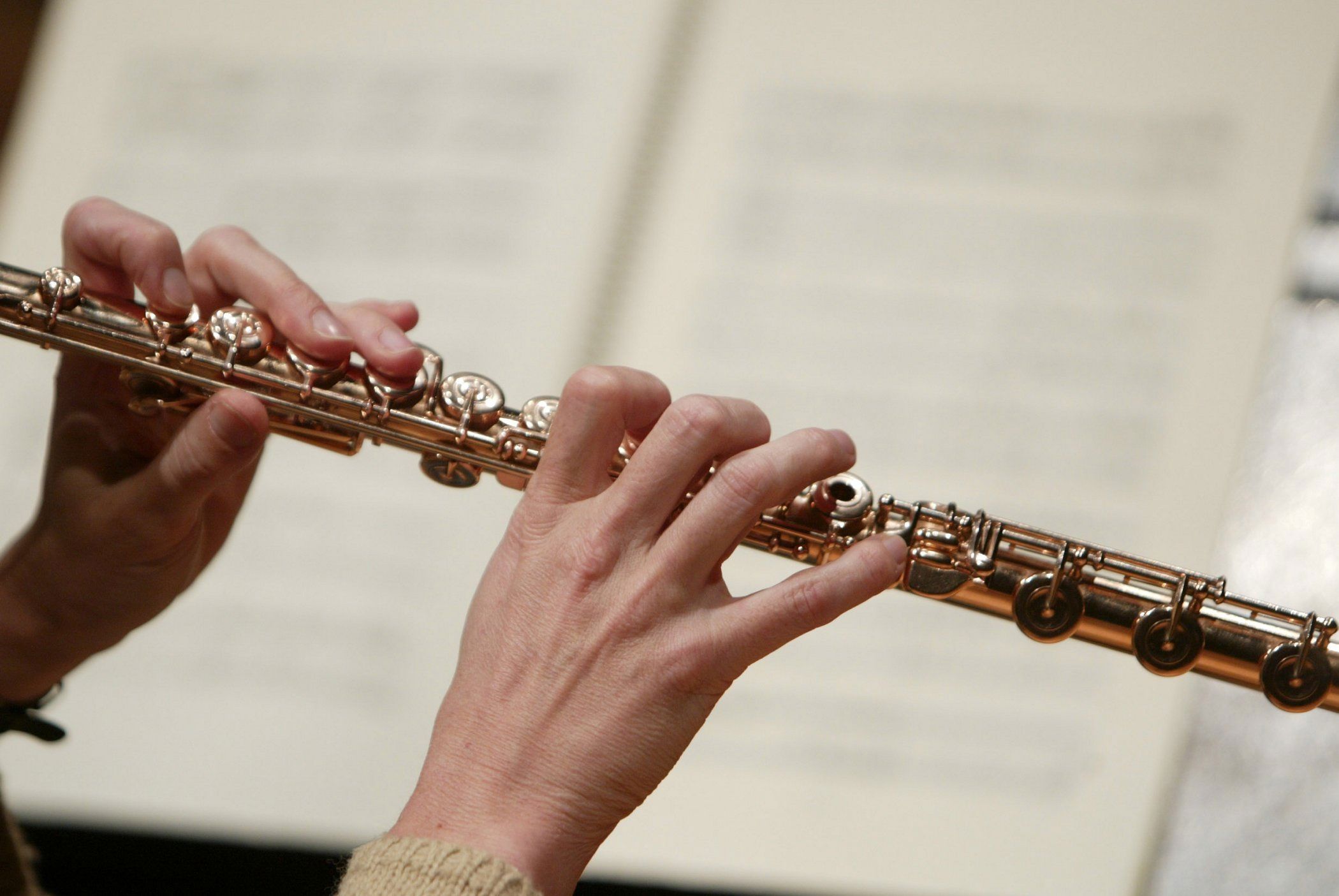 Hænder på tværfløjte foran noder